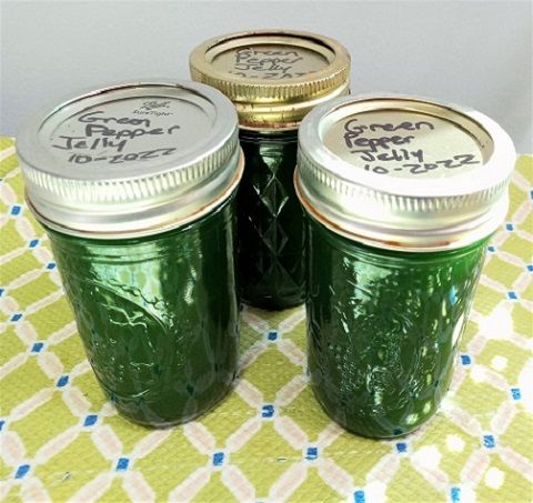 three green mason jars sitting on top of a table