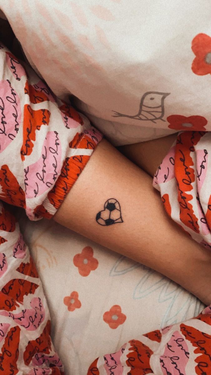 a person laying in bed with their arm wrapped around the pillow and tattoo on his arm