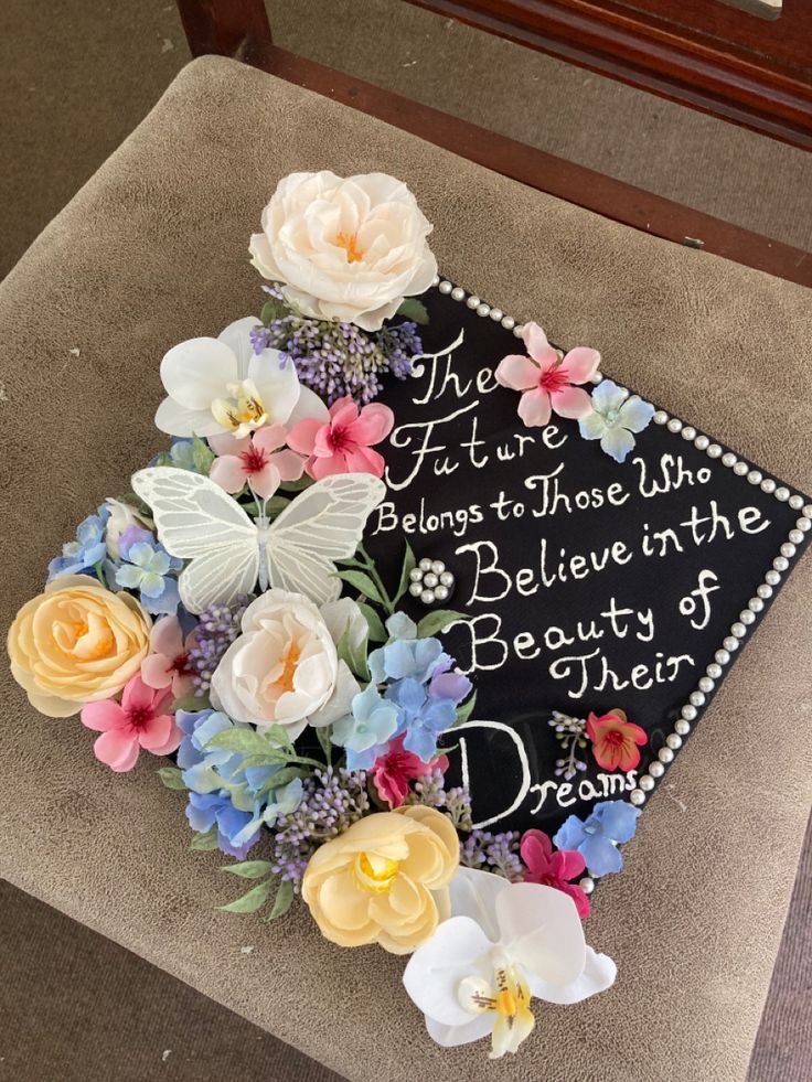 a decorated graduation cap with flowers on it that says, the future belongs those who believe in the beauty of their dreams