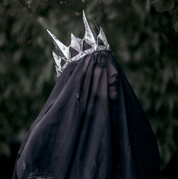 a crown on top of a black cloth with trees in the backgroung