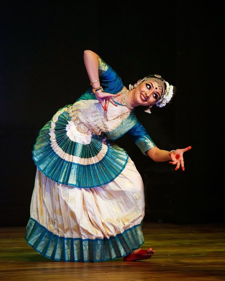 a woman in a blue and white dress is dancing