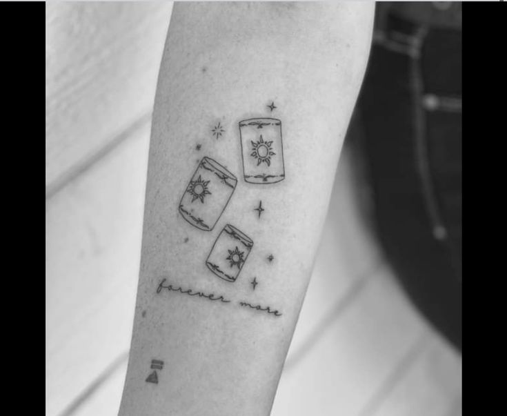 a person with a tattoo on their arm that has two mugs and stars in it