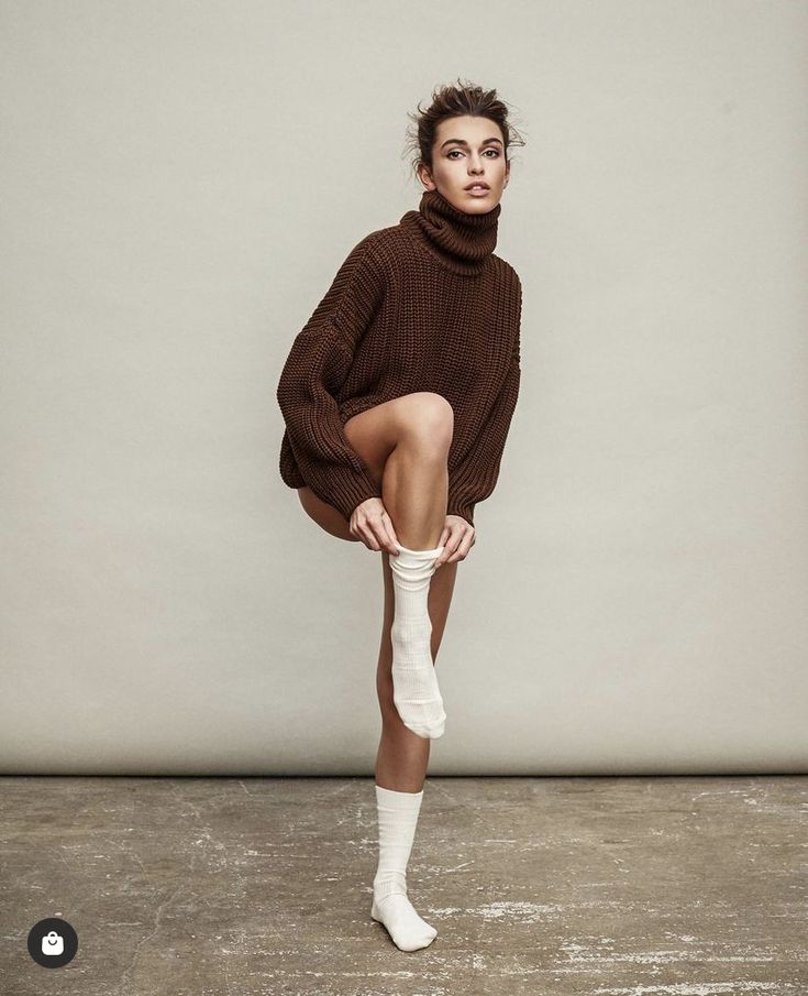 a woman in brown sweater and white socks