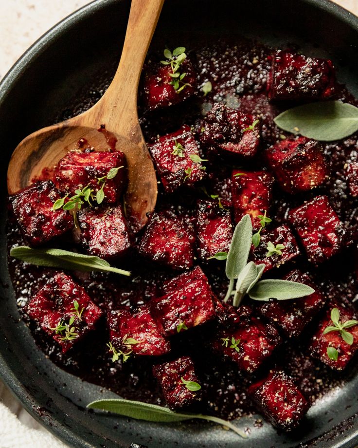 cranberry sauce in a skillet with wooden spoon and sprigs on the side