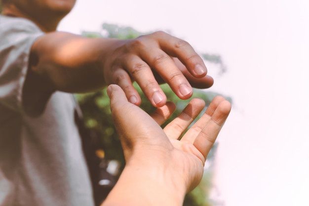 two people reaching out their hands to touch each other