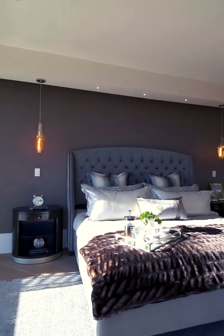 a large bed sitting in the middle of a bedroom next to a wall with lights