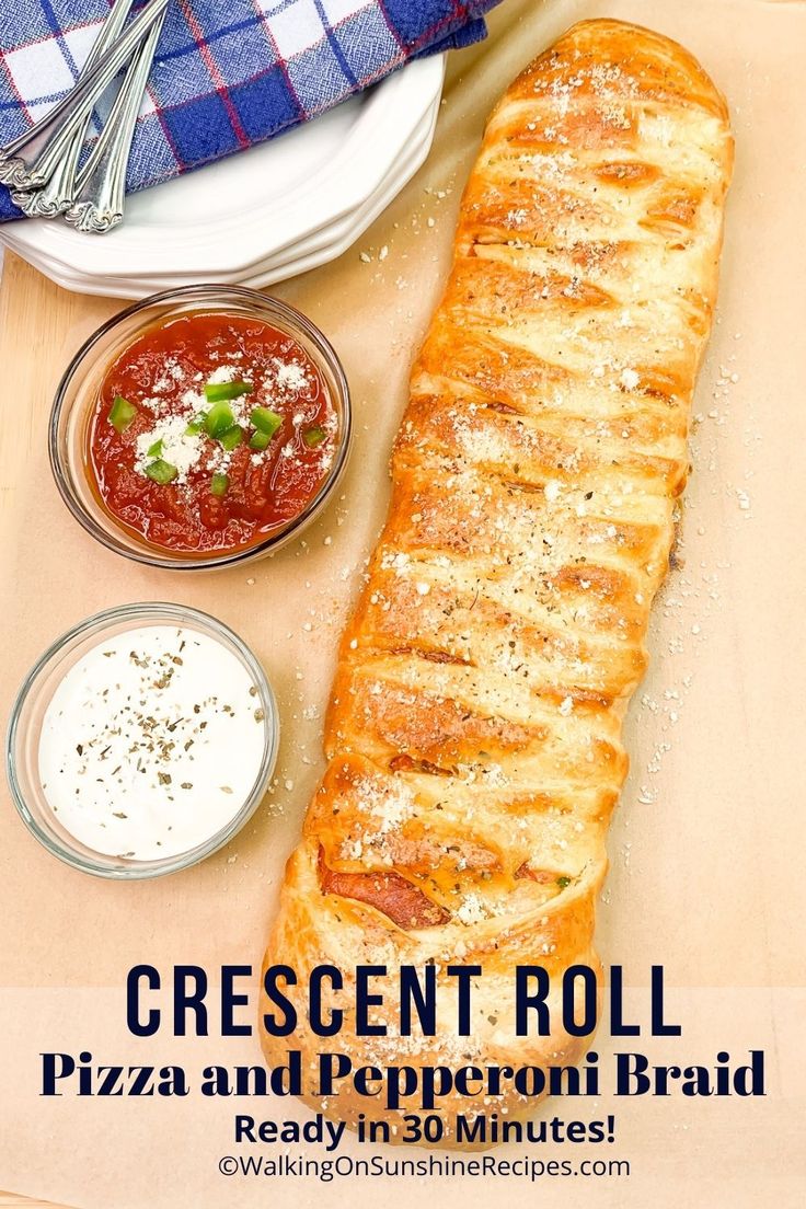 a long piece of bread sitting on top of a cutting board next to some sauces