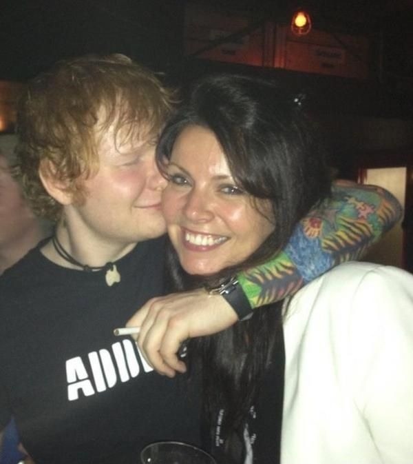 a woman hugging a man with tattoos on his arm