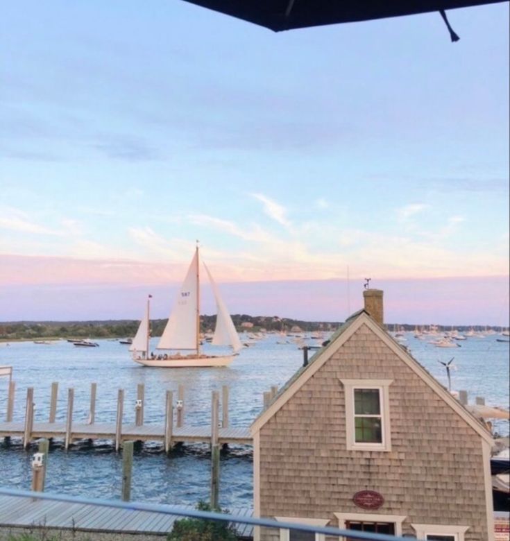 a sailboat is in the water next to a house