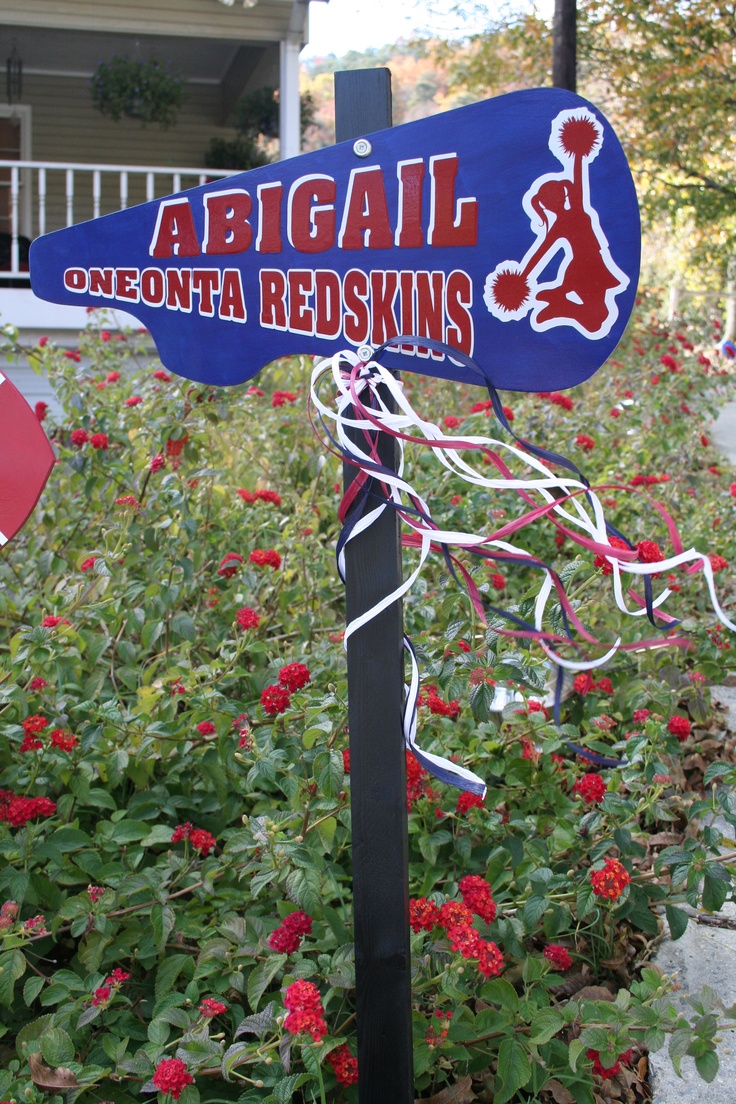 a sign that is in front of some bushes and flowers, with the name abigail on it