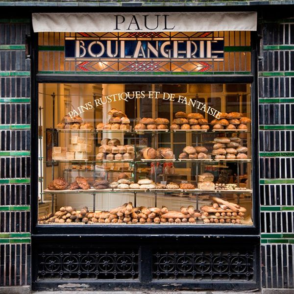 a bakery with lots of baked goods on display in the window and behind it is a sign that says paul boulangerie