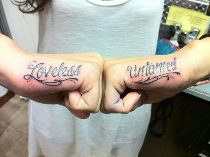 two people with tattoos on their arms that say loveless and unattended in cursive writing