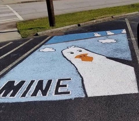 an image of a duck painted on the street in front of a parking lot that says mine