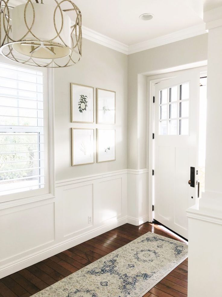 an empty room with white walls and wood flooring is pictured in this image, there are framed pictures on the wall