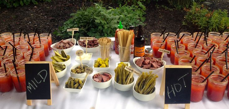 a table topped with lots of different types of drinks and food on top of it