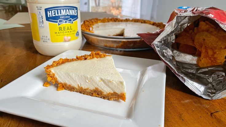 a piece of pie sitting on top of a white plate next to a container of mayonnaise