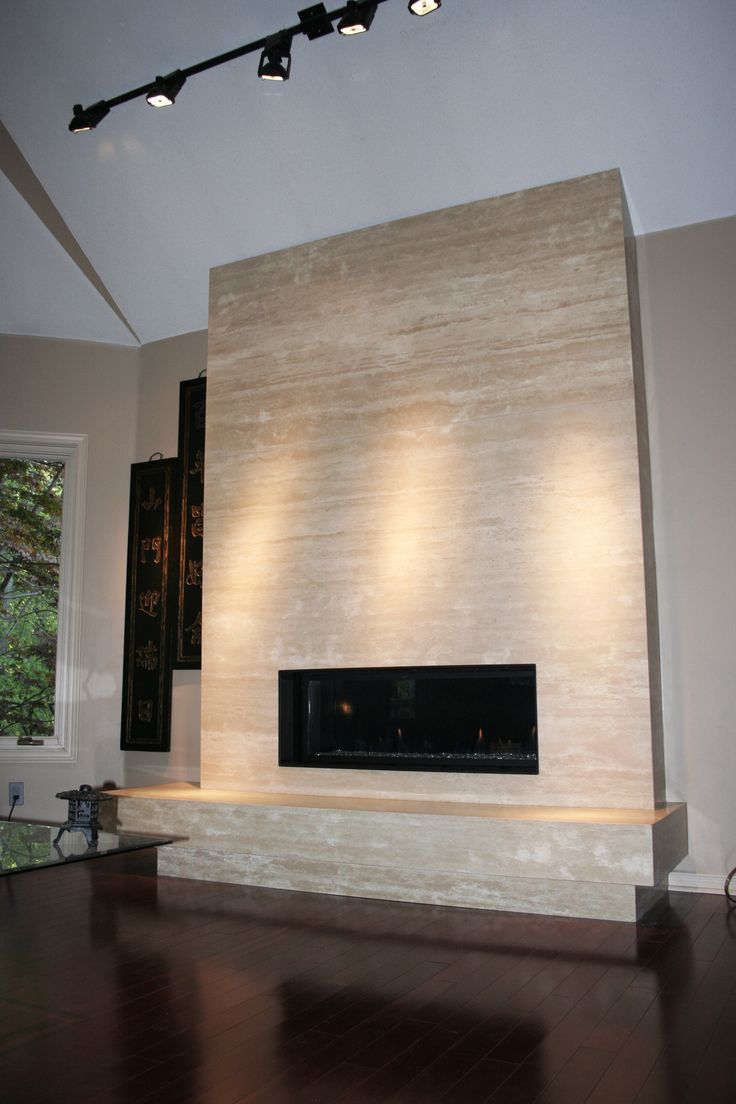 an empty living room with wood flooring and a large wall mounted tv above the fireplace