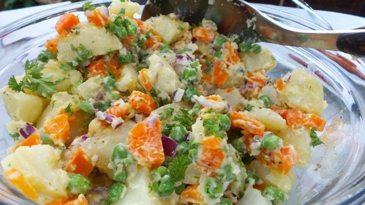 a glass bowl filled with potatoes and carrots