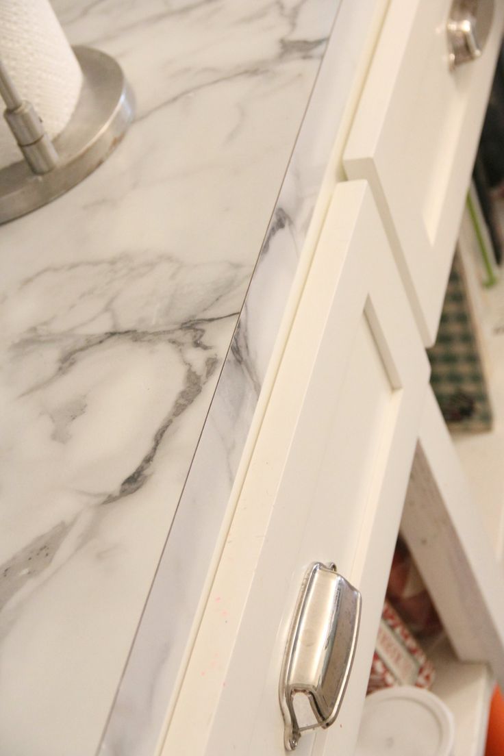 an open drawer in a kitchen with marble counter tops