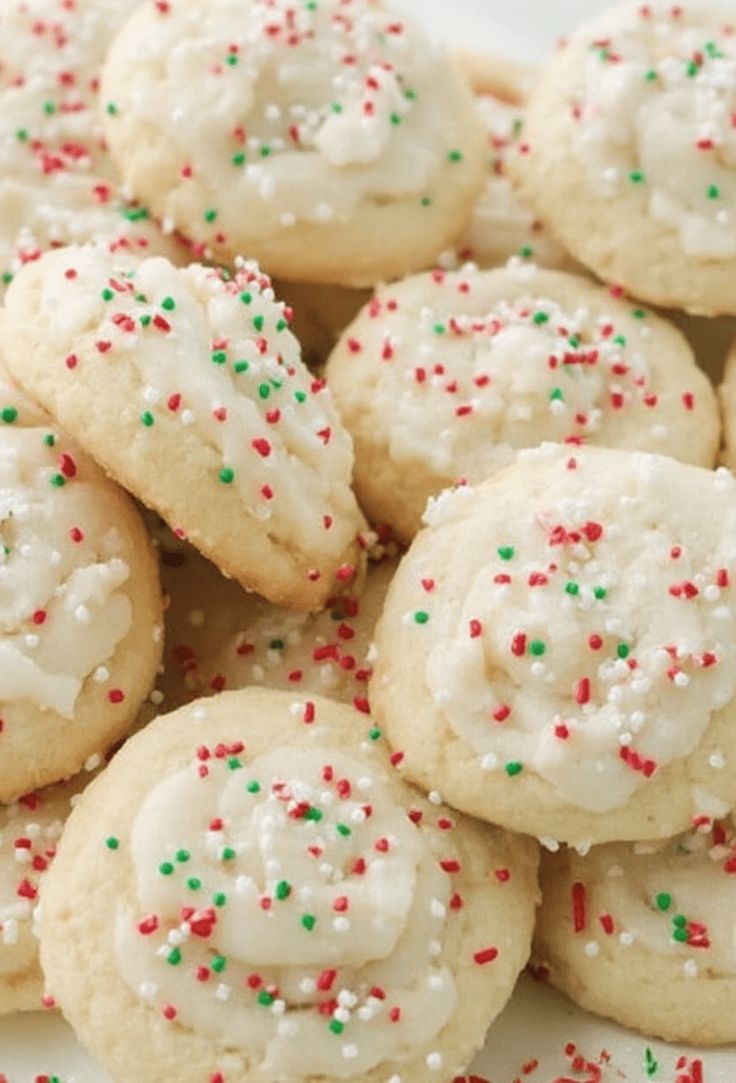 a white plate topped with cookies covered in frosting and sprinkles on top of each other