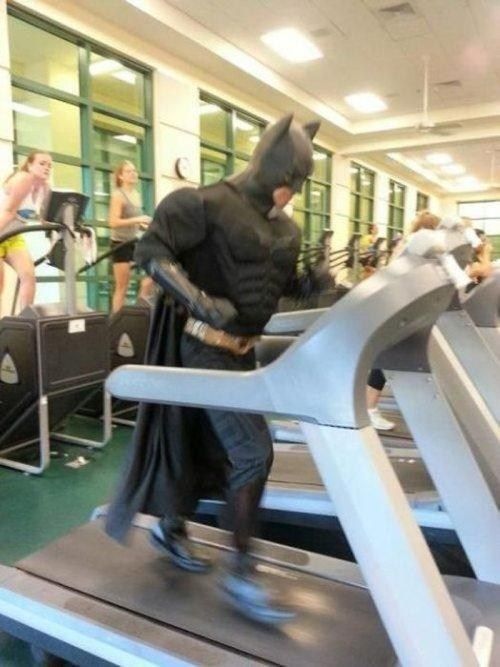 a man dressed as batman running on a treadmill