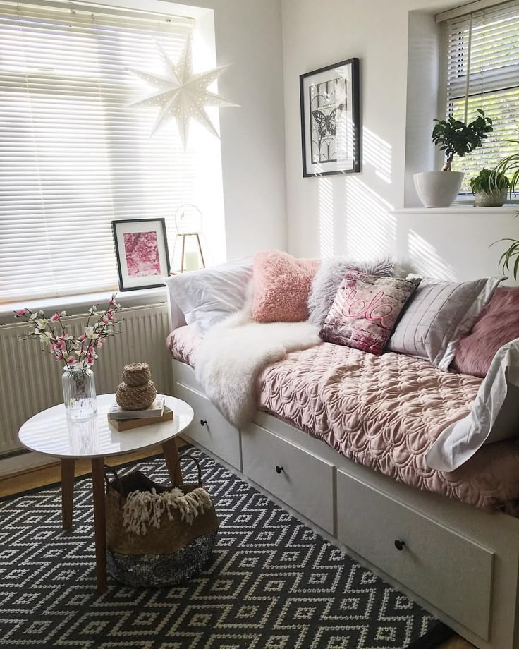 a living room filled with lots of furniture and decor on top of a rug next to a window