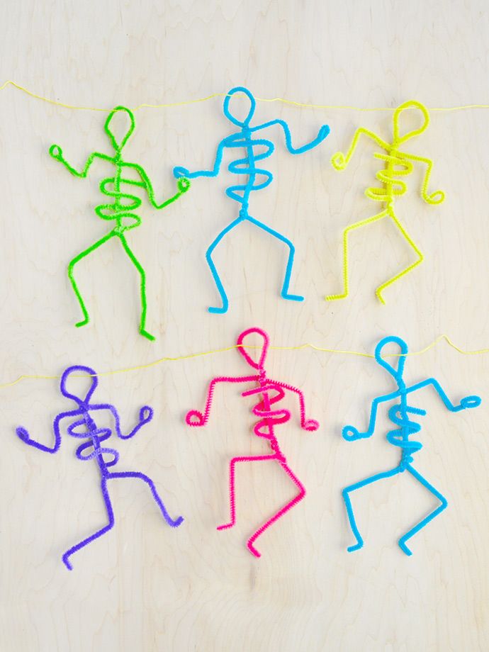 several colorful plastic figures on a white surface with string attached to the strings in front of them