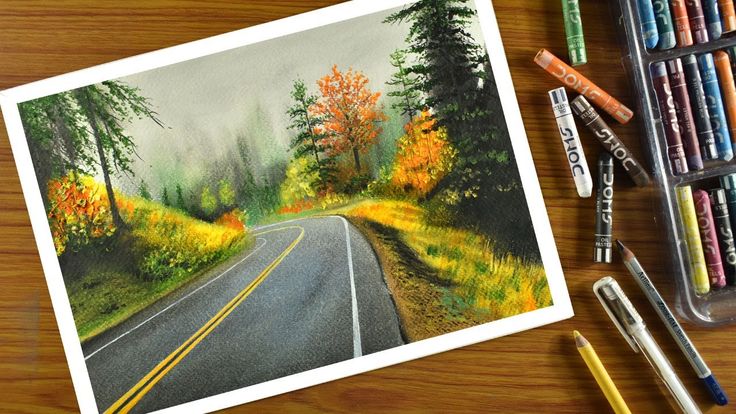 a drawing of a road surrounded by crayons and colored pencils on a table