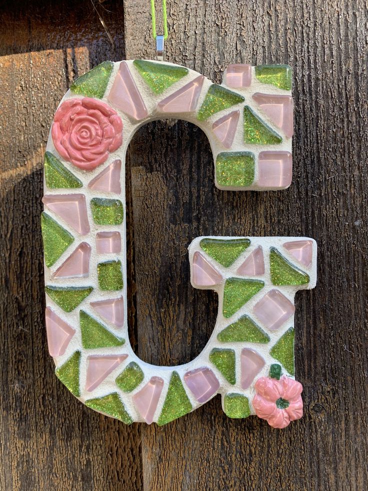 the letter c is made out of glass and has flowers on it's side