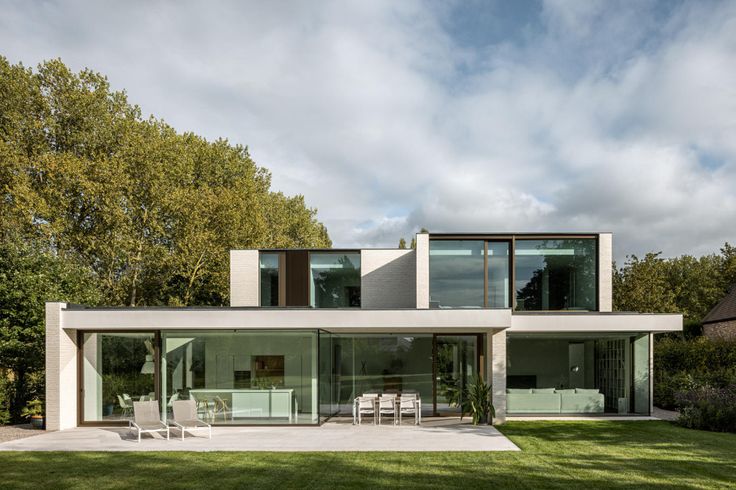 a modern house in the middle of a lush green field