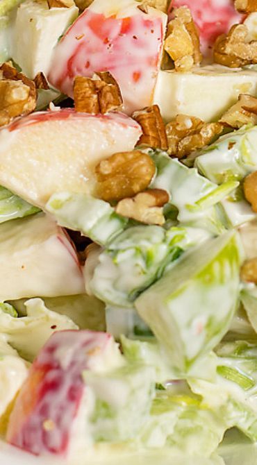 a salad with apples and walnuts in it