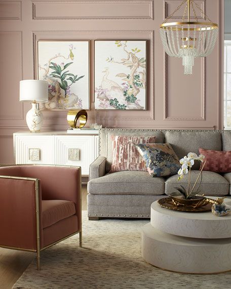 a living room filled with furniture and paintings on the wall next to a table in front of a window