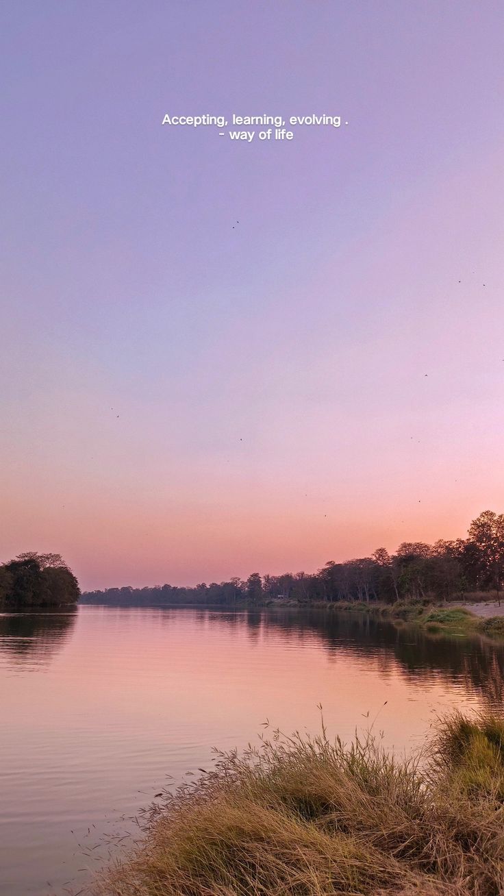 the water is calm and peaceful at sunset or dawn, as seen from across the river