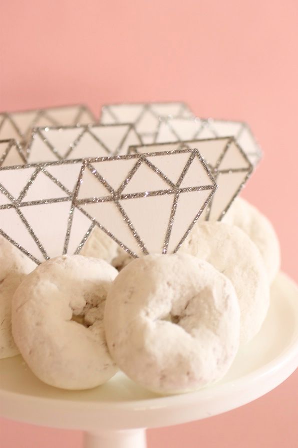 doughnuts are sitting on a cake plate with a geometric design in the background