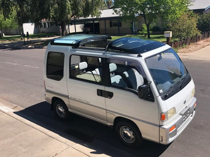 the small van is parked on the side of the road with its luggage strapped to it's roof