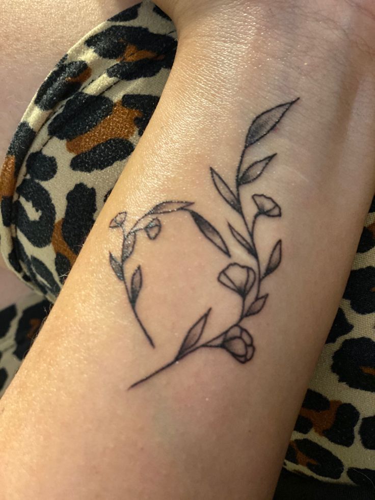 a woman's arm with a small tattoo design on the left side of her arm