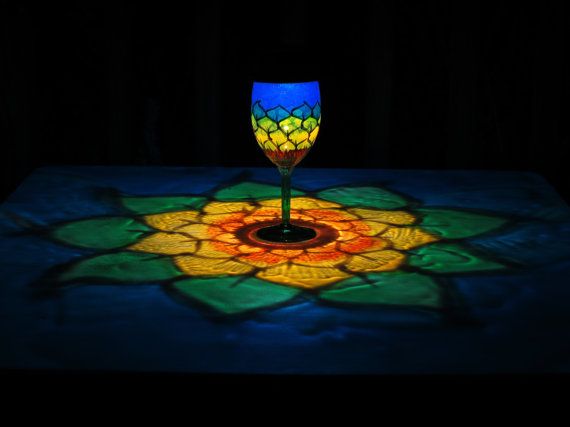 a lit up wine glass sitting on top of a table