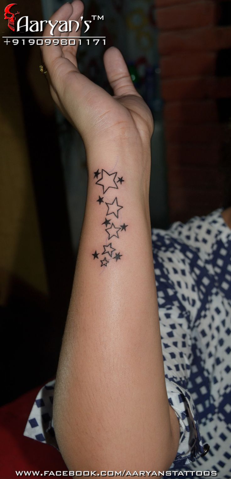 a woman's arm with stars tattoo on it