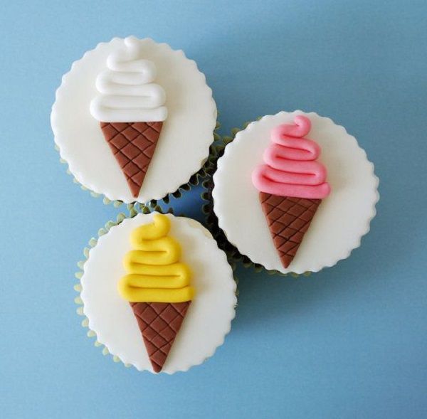 three ice cream cupcakes with icing on them sitting next to each other