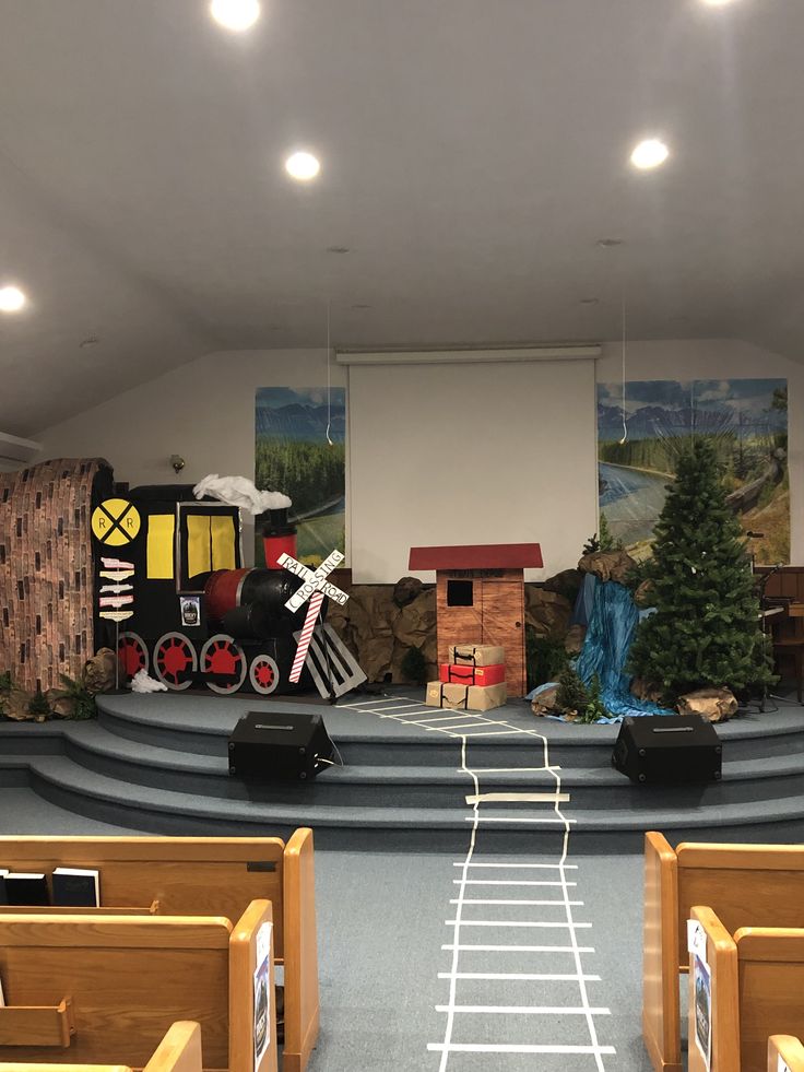 an empty church filled with wooden pews and decorated stage for children to play on