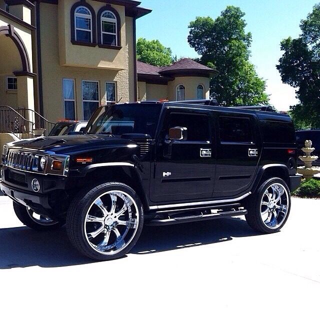 a black hummer truck parked in front of a house