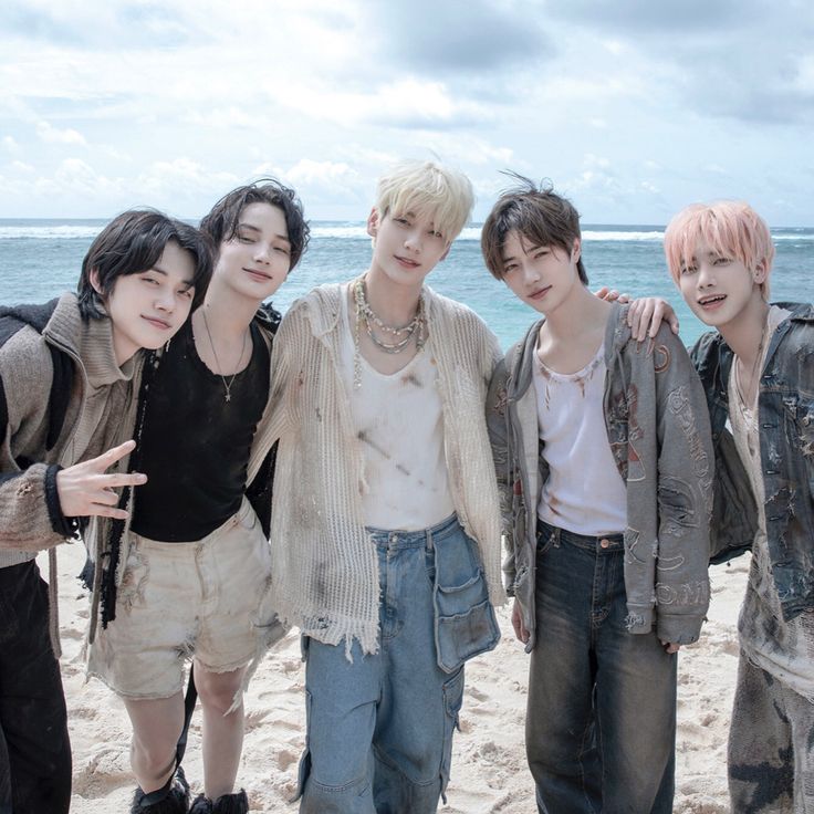 group of young men standing next to each other on the beach