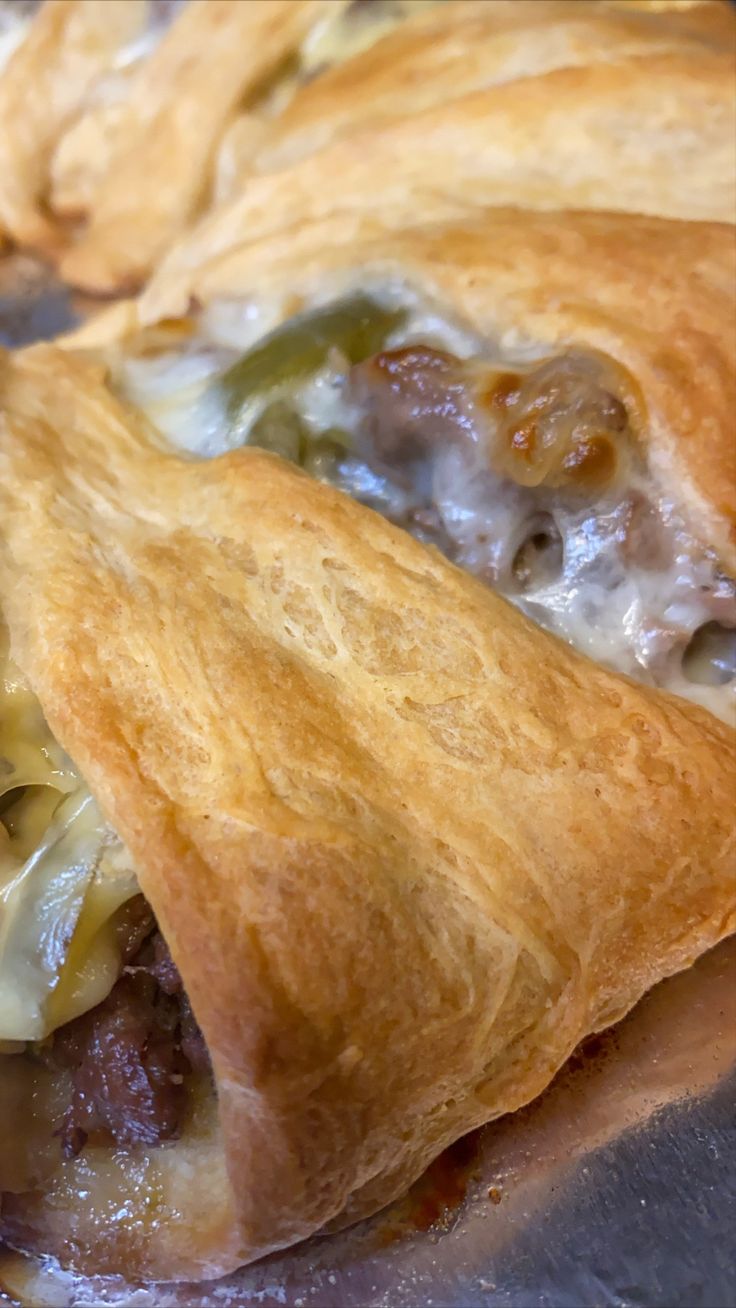 two pastries with meat, cheese and vegetables in them sitting on a table top