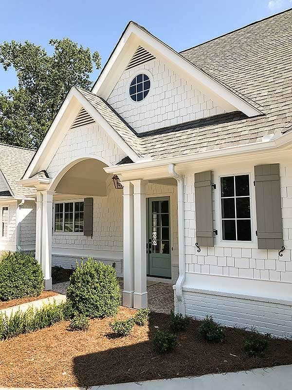 a white house with black shutters on the front