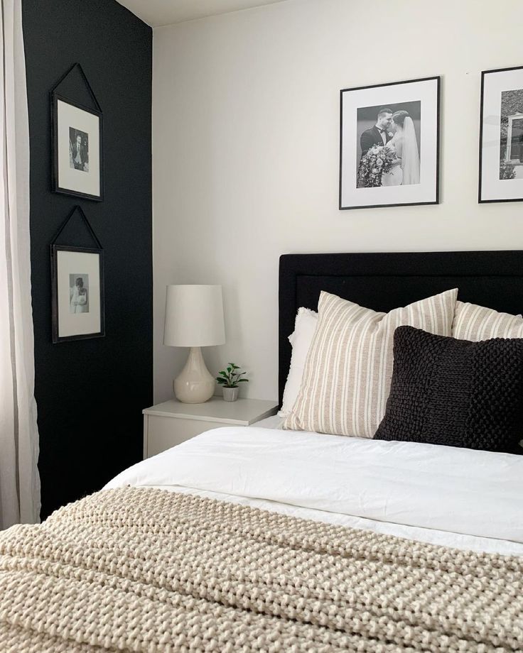 a bedroom with black and white decor on the walls