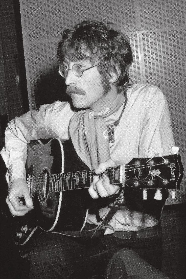 black and white photograph of a man playing an acoustic guitar