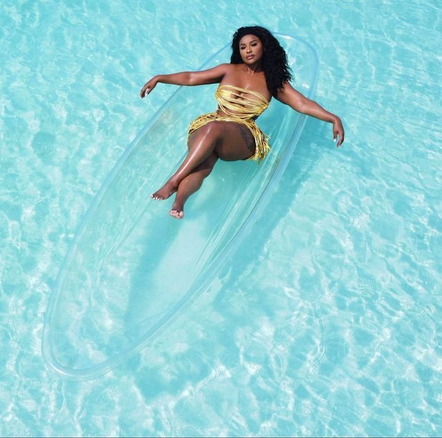 a woman in a yellow swimsuit is floating on a clear blue pool with an inner tube