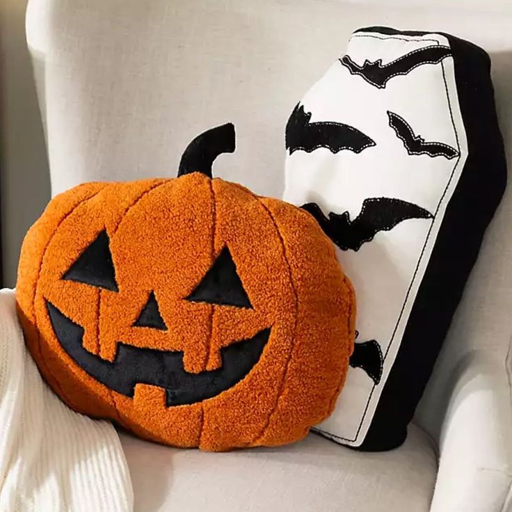 a pumpkin pillow sitting on top of a white chair