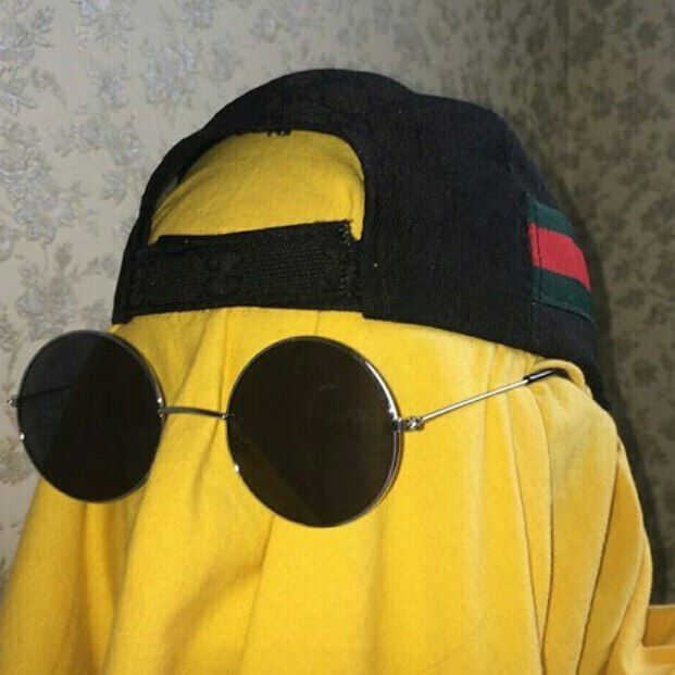 a person wearing sunglasses and a yellow jacket with a black hat on it's head