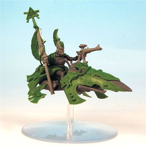 a toy figurine sitting on top of a green dragon with a spear in its hand